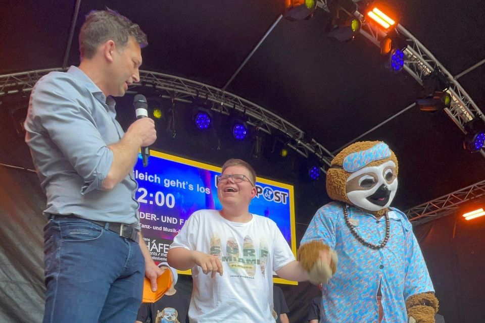 Sebastian Häfker mit Kindern und Maskottchen auf der Bühne