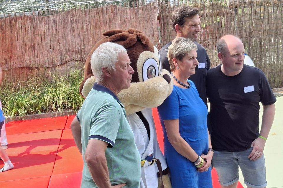 Das stolze Team mit Maskottchen beobachtet eine Aktion